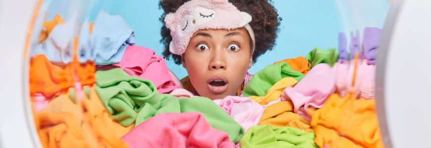 Stunned woman surrounded by a pig pile of laundry