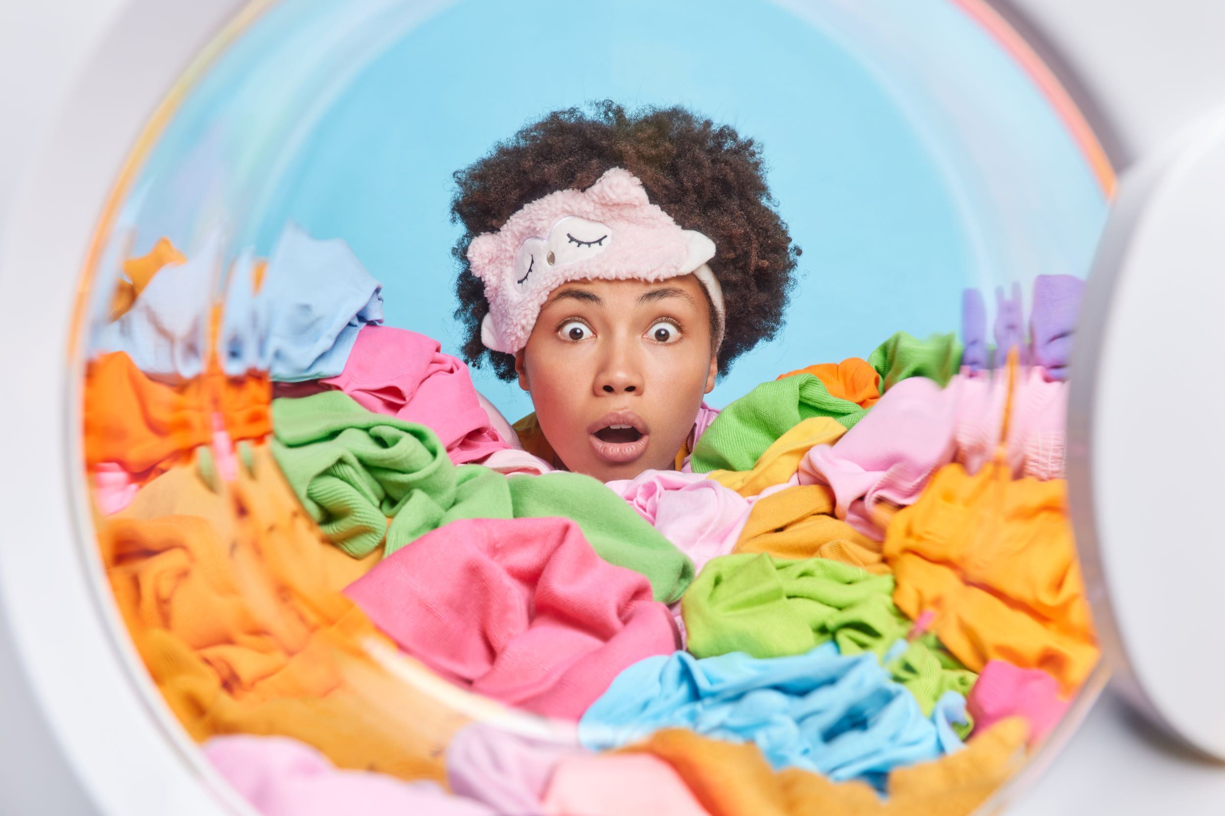 Stunned woman surrounded by a pig pile of laundry